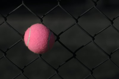灰色钢栅栏上的红色网球
